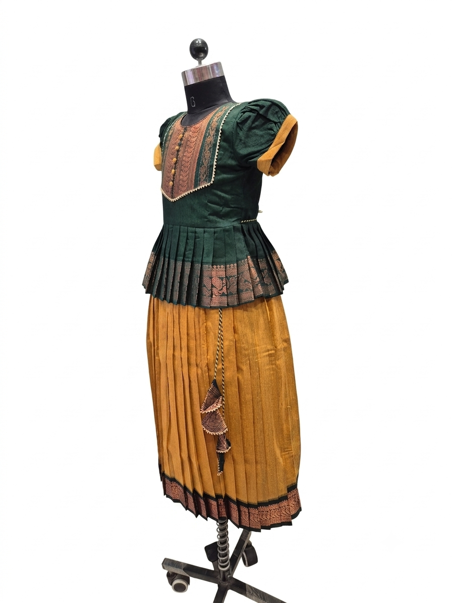 A vintage-style two-piece dress displayed on a black dress form mannequin against a plain white background. The dress features a dark green short-sleeve top with gold trim and a pleated gold skirt with dark patterned trim - House of Kritee