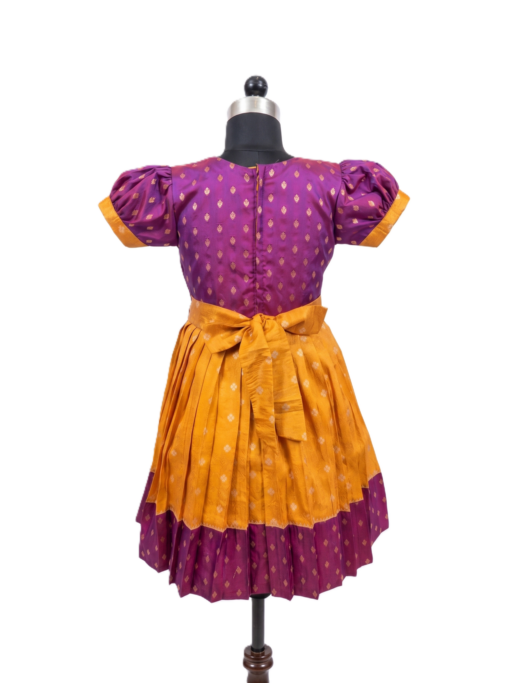A traditional Indian salwar suit displayed on a black dress form mannequin against a white background. The outfit features a purple kurta with gold polka dots and puffed sleeves, paired with a matching pleated yellow-orange skirt that has a purple border and a tied waist sash. - House of Kritee