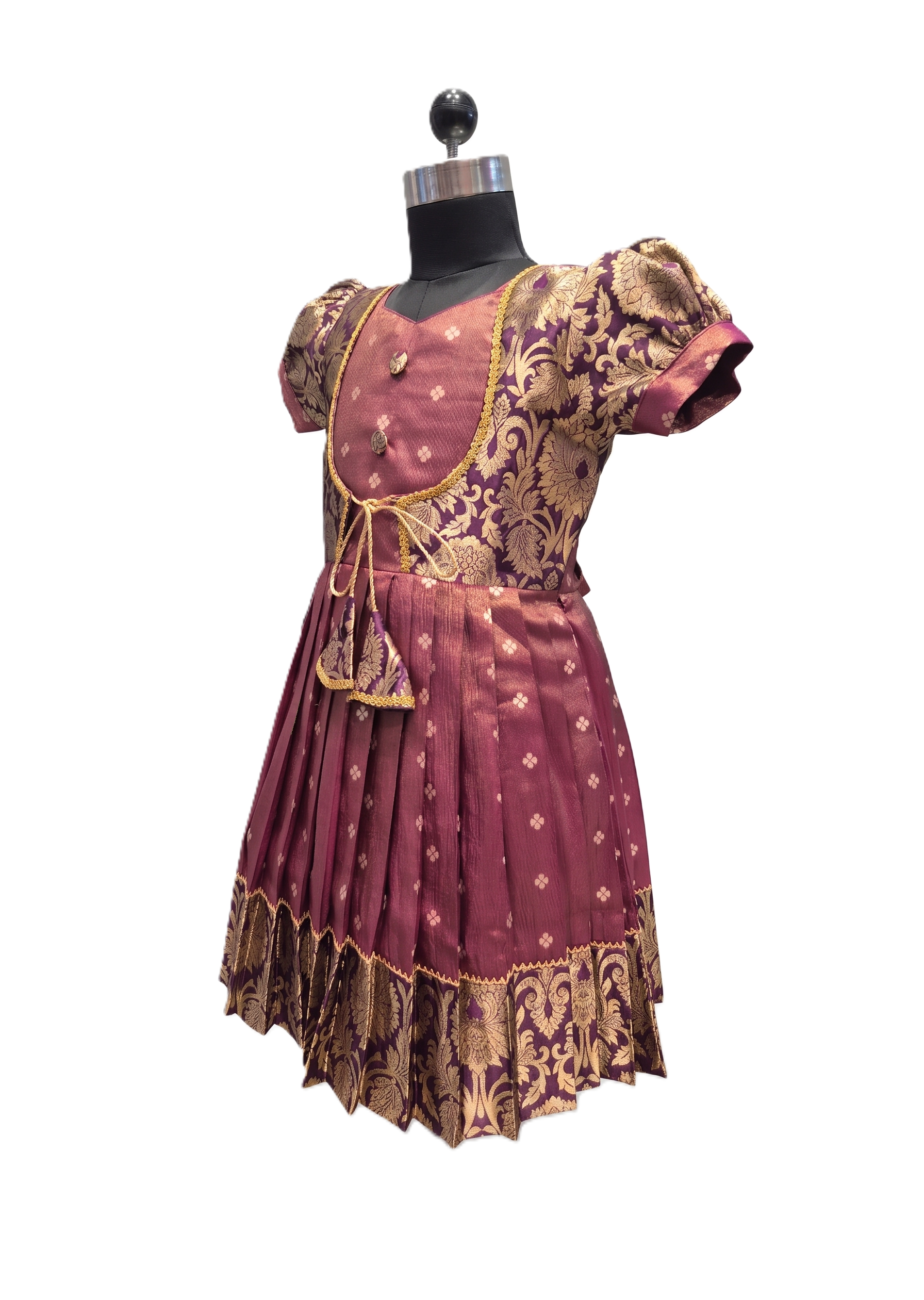 A traditional Indian dress displayed on a black dress form mannequin against a white background. The dress is maroon with gold and beige floral patterns and has short puff sleeves. - House of Kritee