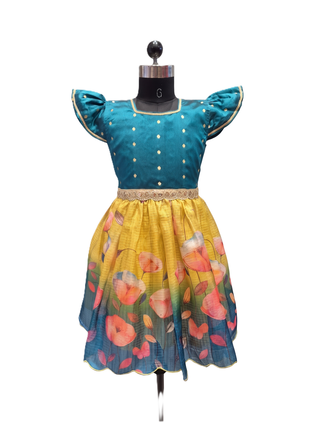 A children's dress displayed on a black dress form against a plain white background. The dress has a teal blue bodice with gold polka dots and puffed cap sleeves, a gold waistband, and a yellow-to-blue gradient skirt with a floral print. - House of Kritee