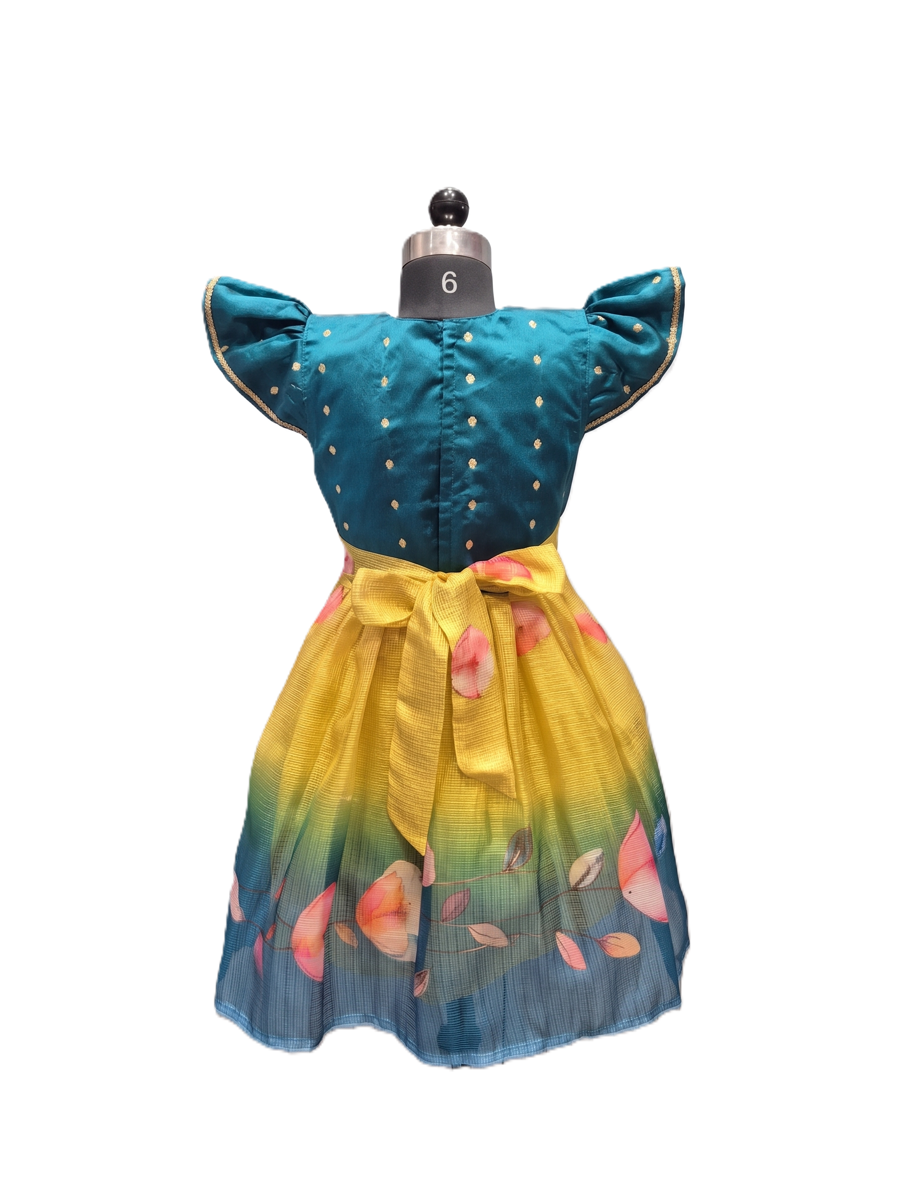 A toddler girl's two-piece dress displayed on a mannequin against a white background. The set features a teal blue top with gold polka dots and flutter sleeves, paired with a yellow-to-blue gradient skirt decorated with pink floral prints. - House of Kritee