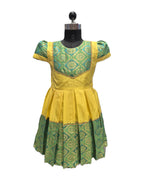 A yellow and green patterned dress displayed on a black dress form mannequin against a plain white background. - House of Kritee