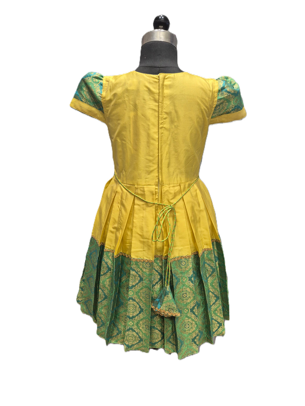 A yellow and green patterned dress displayed on a black dress form mannequin against a plain white background. - House of Kritee