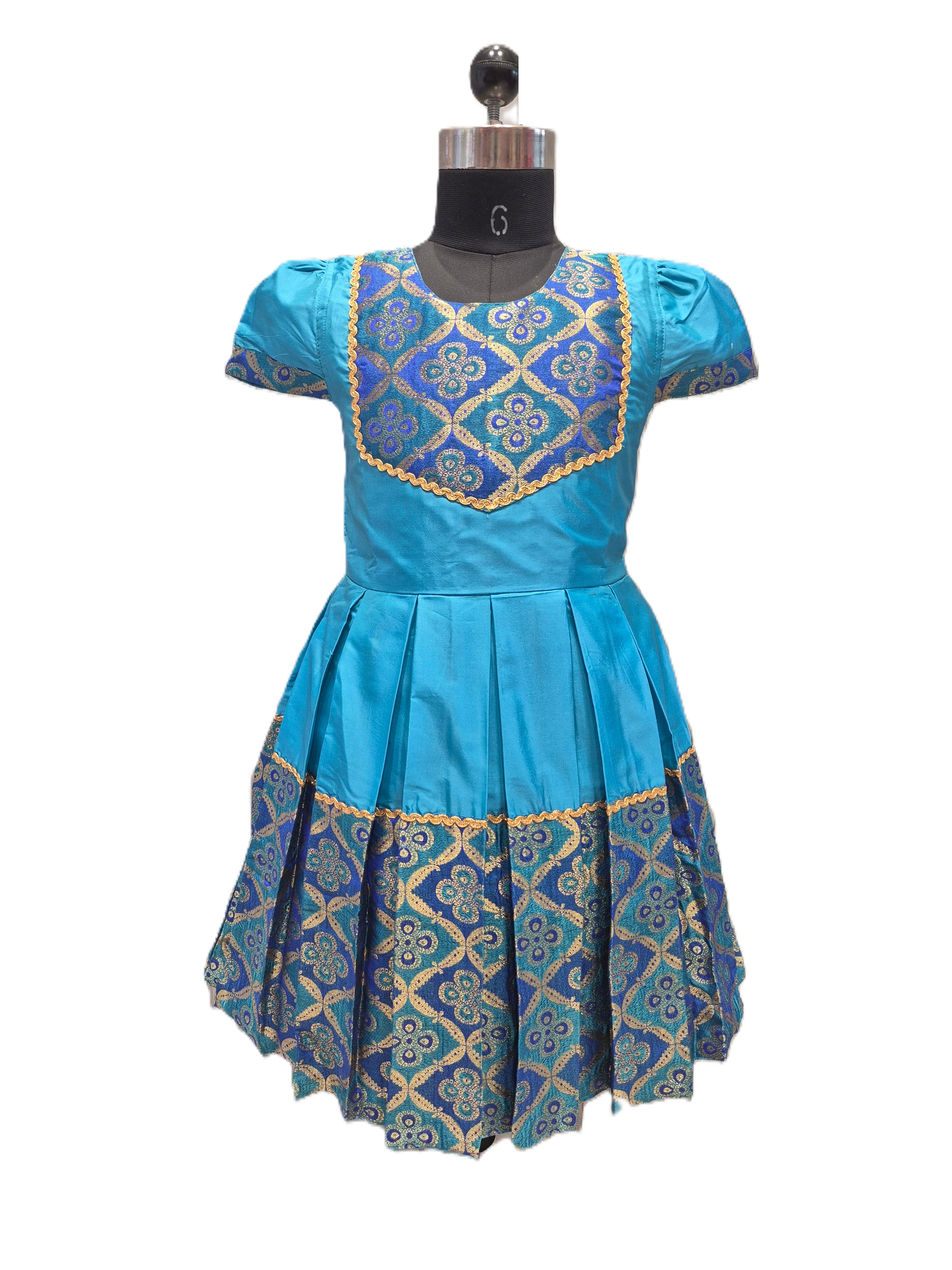 A blue short-sleeved dress displayed on a black dress form mannequin against a white background. The dress features a pleated skirt and a bodice with blue and gold geometric embroidery. - House of Kritee