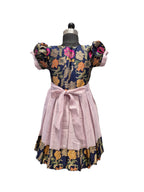 A vintage-style dress displayed on a black dress form mannequin against a white background. The dress features a navy blue floral bodice with pink, orange, and gold patterns, a light pink pleated skirt, and a matching pink waist bow. - House of Kritee
