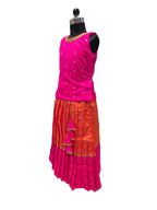 A sleeveless traditional outfit displayed on a black dress form mannequin against a plain white background. The outfit features a bright pink sleeveless top with small gold motifs and a matching pleated skirt in orange and pink with gold accents. - House of Kritee
