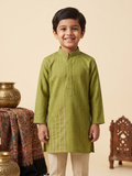 A happy Desi boy model wearing a premium olive green silk kurta paijama set against a warm cream background - House of Kritee