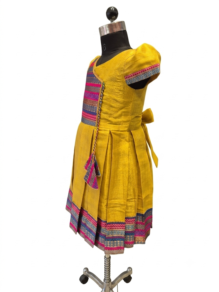 Happy Desi girl model wearing a yellow silk Angrakha knee length ethnic frock with geometric border - House of Kritee
