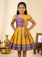Happy Desi girl model wearing a yellow silk Angrakha knee length ethnic frock with geometric border - House of Kritee