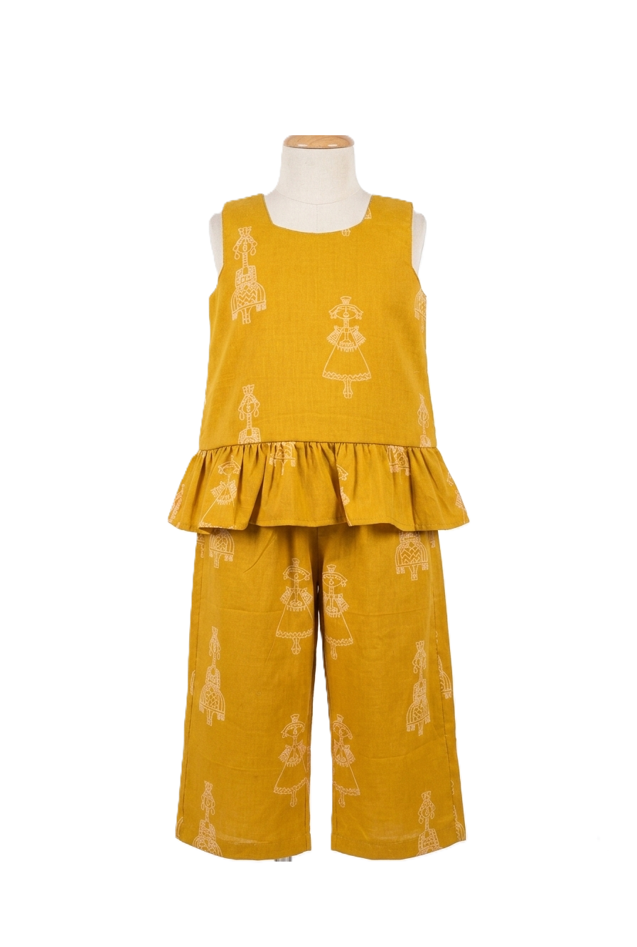 Girls mustard yellow cotton co-ord set with sleeveless peplum top and wide-leg trousers featuring folk ethnic motifs on a mannequin