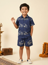 A young boy modeling a navy blue two-piece kurta set with white floral patterns, standing against a warm beige background - House of Kritee