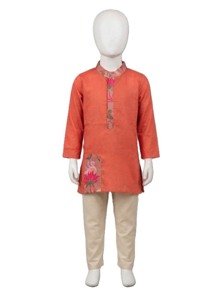 Young boy smiling in rust orange printed kurta and beige pajama set