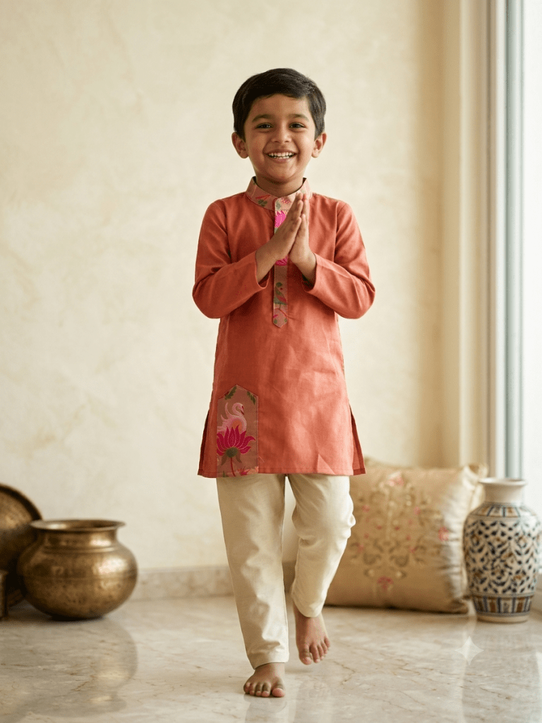 Young boy smiling in rust orange printed kurta and beige pajama set