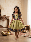 Happy young girl enjoying her premium navy blue and gold brocade silk knee-length ethnic frock in a warm cream living room setup - House of Kritee