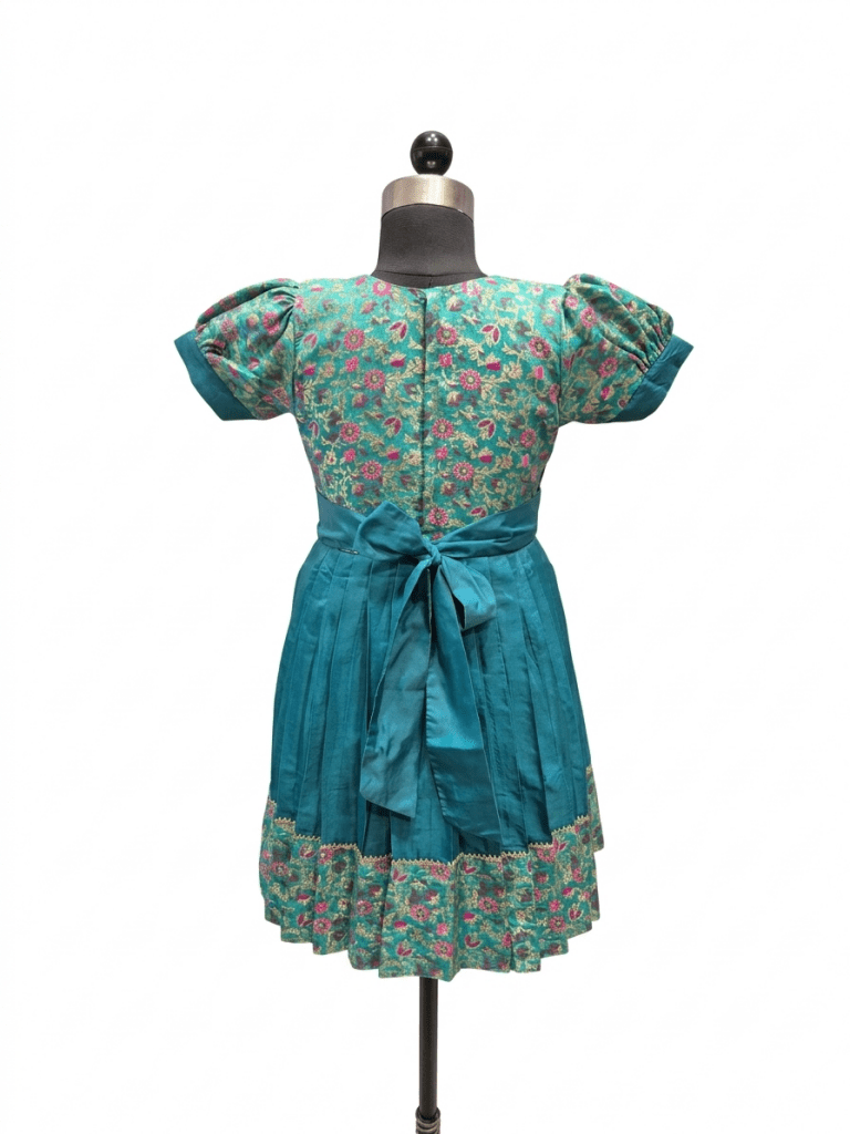 Little girl wearing teal ethnic silk frock with traditional floral jacket"