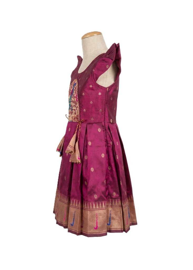 A sleeveless magenta pink traditional Indian dress displayed on a mannequin torso against a white background. The dress features a heavily embroidered bodice with gold and multicolor details, a flared skirt with gold zari motifs, and a wide gold border at the hem.