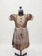 Girl model wearing ethnic jacket style silk frock with traditional golden zari border and tassels