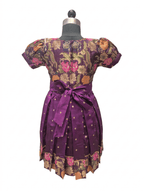Young Indian girl smiling in a royal purple ethnic silk frock with floral brocade and gold zari details