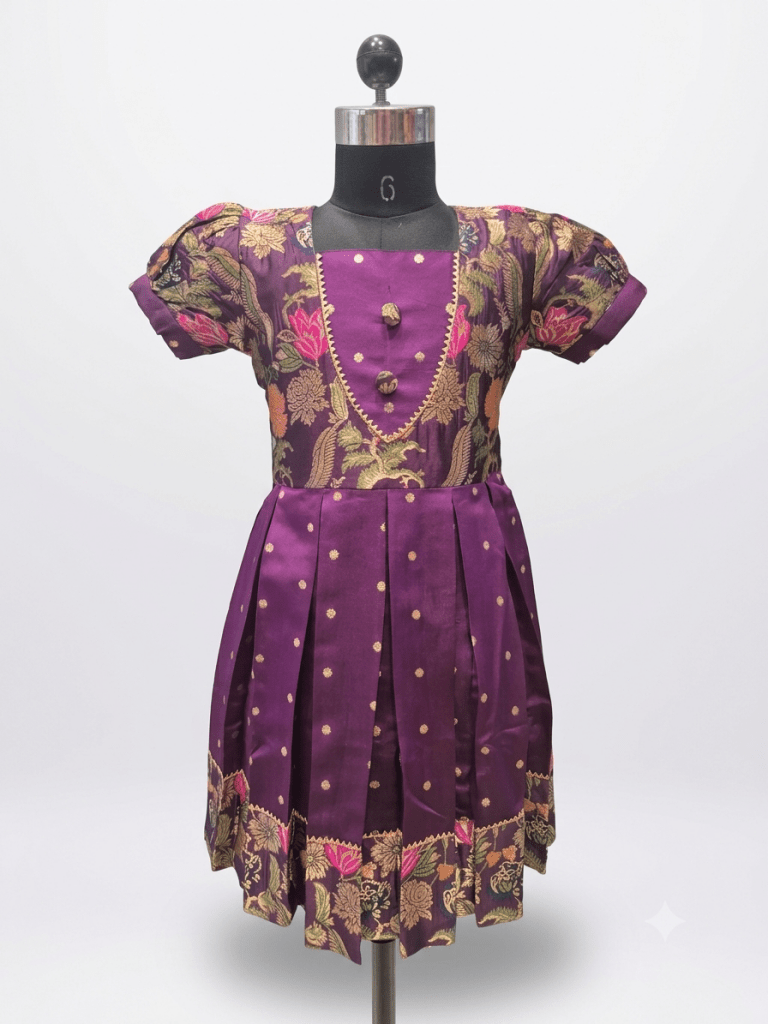 Young Indian girl smiling in a royal purple ethnic silk frock with floral brocade and gold zari details
