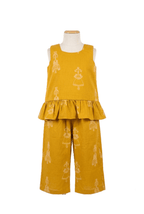 Girls mustard yellow cotton co-ord set with sleeveless peplum top and wide-leg trousers featuring folk ethnic motifs on a mannequin