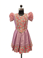 Happy Desi girl model wearing a soft lilac pink silk knee length frock with organza puff sleeves - House of Kritee
