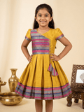Happy Desi girl model wearing a yellow silk Angrakha knee length ethnic frock with geometric border - House of Kritee