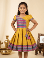 Happy Desi girl model wearing a yellow silk Angrakha knee length ethnic frock with geometric border - House of Kritee