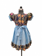 A short-sleeve dress displayed on a mannequin against a plain white background. The dress has a dark navy floral bodice with orange, yellow, and pink flowers, light blue puff sleeves, a matching light blue waist tie, and a light blue flared skirt with a dark floral ruffled hem.  - House of Kritee