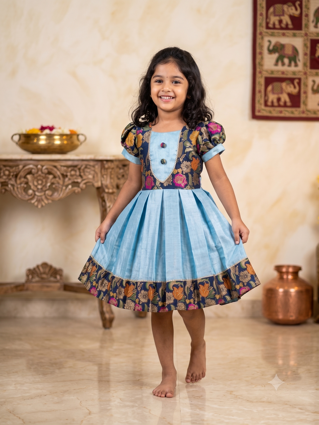 Happy young girl enjoying her premium sky blue and navy floral brocade silk knee-length ethnic frock in a warm cream room setup - House of Kritee
